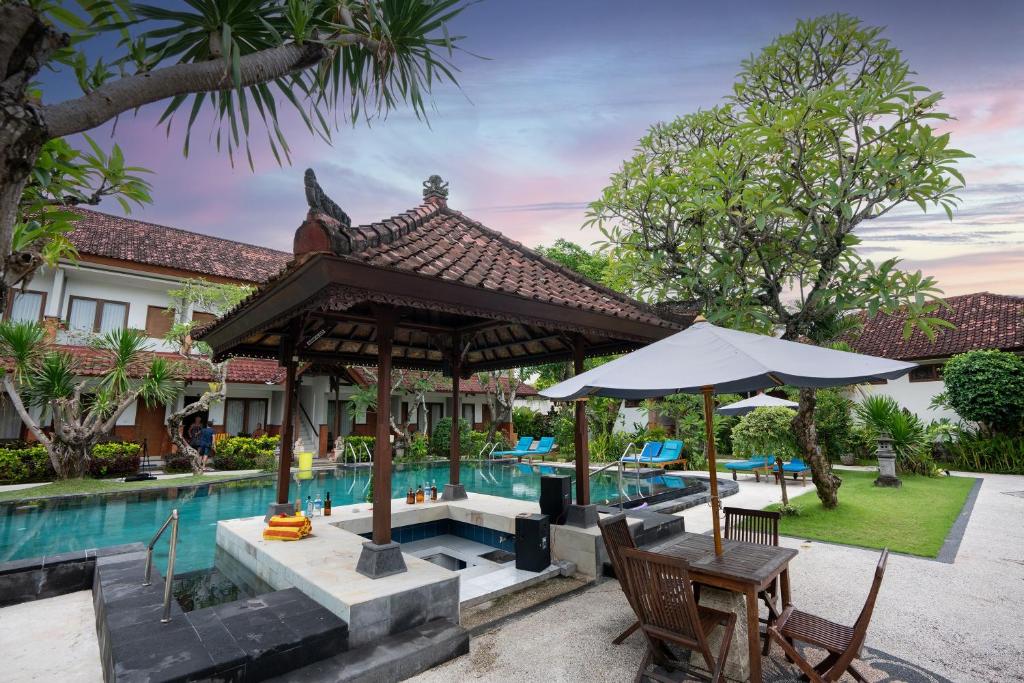 um pátio exterior com um pavilhão ao lado de uma piscina em Sinar Bali Hotel em Legian
