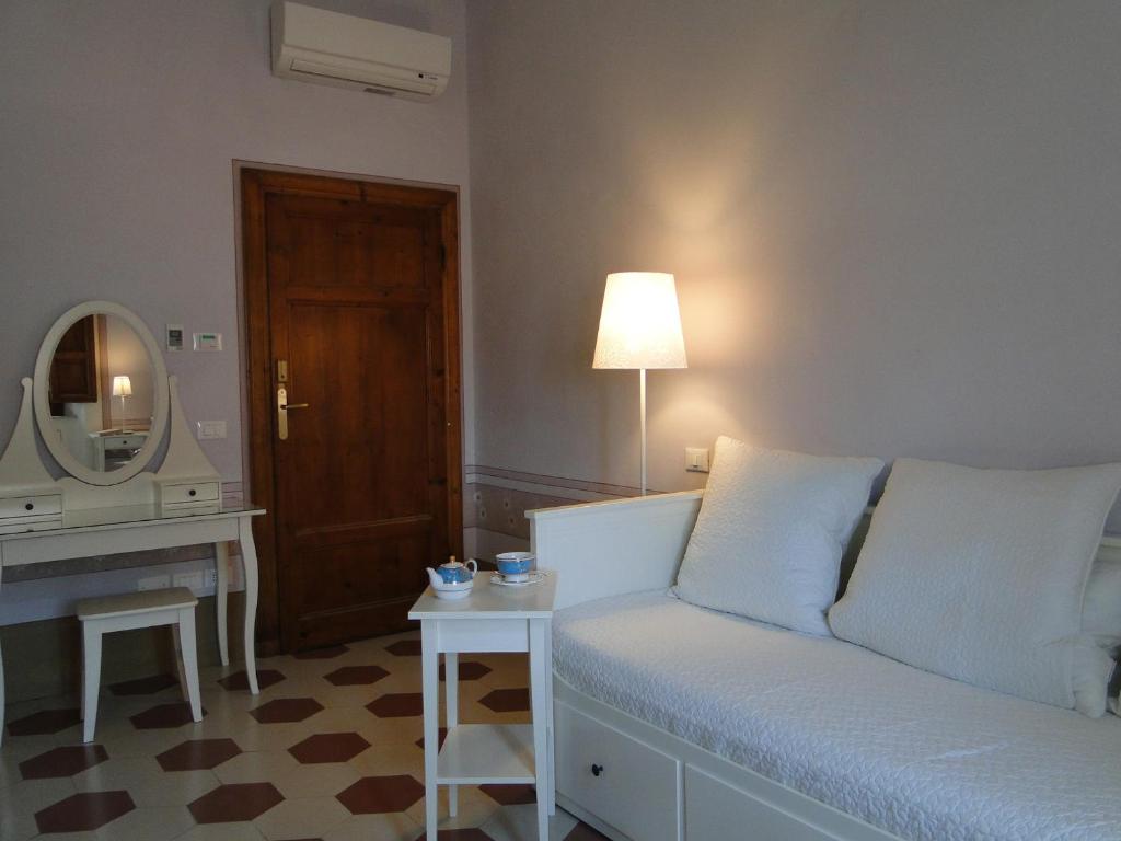 a living room with a couch and a mirror at Villino Ermione in Marina di Pisa