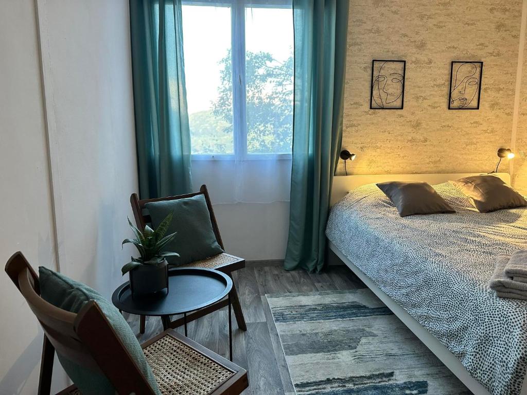 a bedroom with a bed and a table and a window at Olívia Vendégház Orfű in Orfű