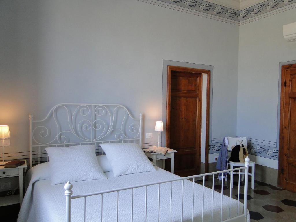 a bedroom with a white bed with two white pillows at Villino Ermione in Marina di Pisa