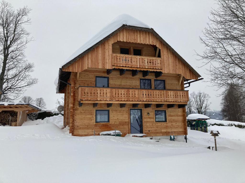 Cabaña de madera con balcón en la nieve en Chalet Reiterhäusl, en Ramsau am Dachstein