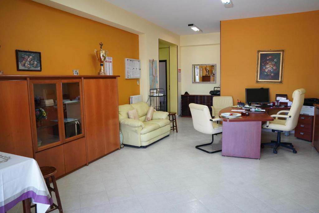 uma sala de estar com paredes amarelas e uma mesa e cadeiras em B&B Vistamare em Villa San Giovanni