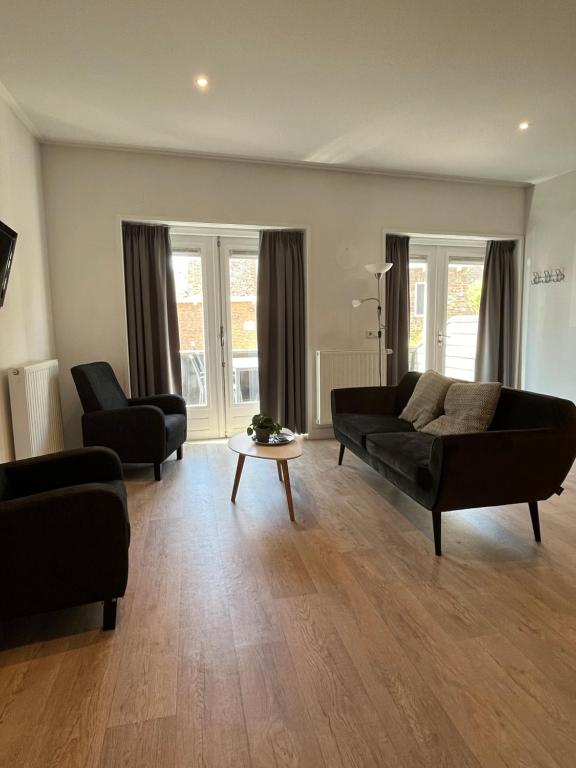 - un salon avec un canapé et une table dans l'établissement Appartementen het Centrum, à Domburg
