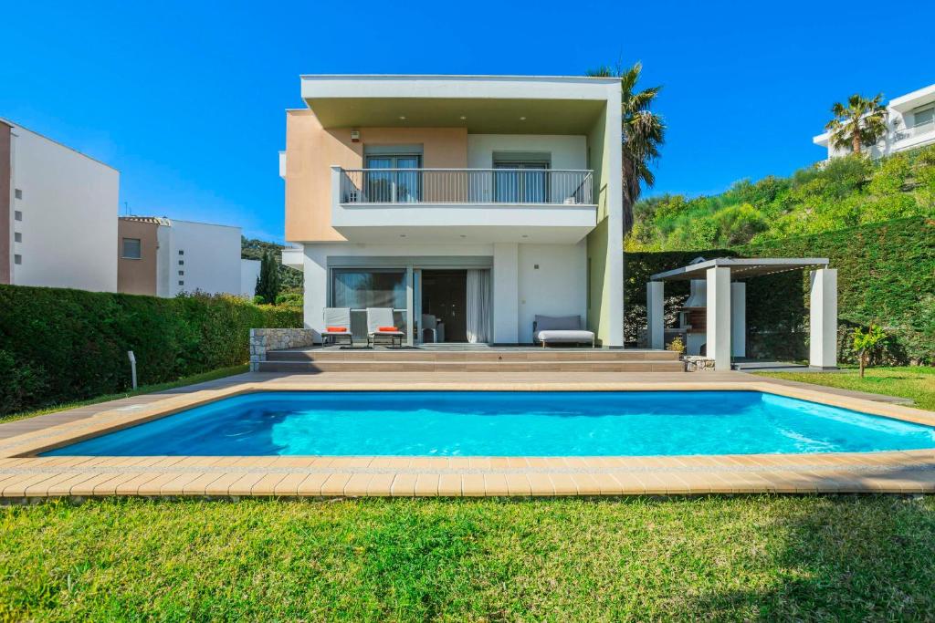 a villa with a swimming pool in front of a house at Aegean Sea View Villa in Pefkochori
