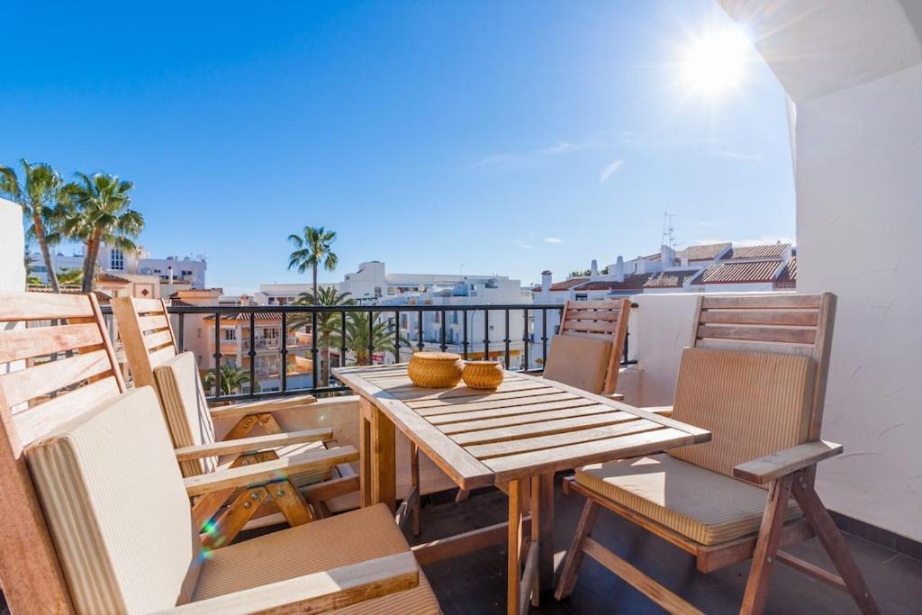 drewniany stół i krzesła na balkonie w obiekcie Canovas Nerja - Alcazaba Parador, piscina, 2 dorm w mieście Nerja