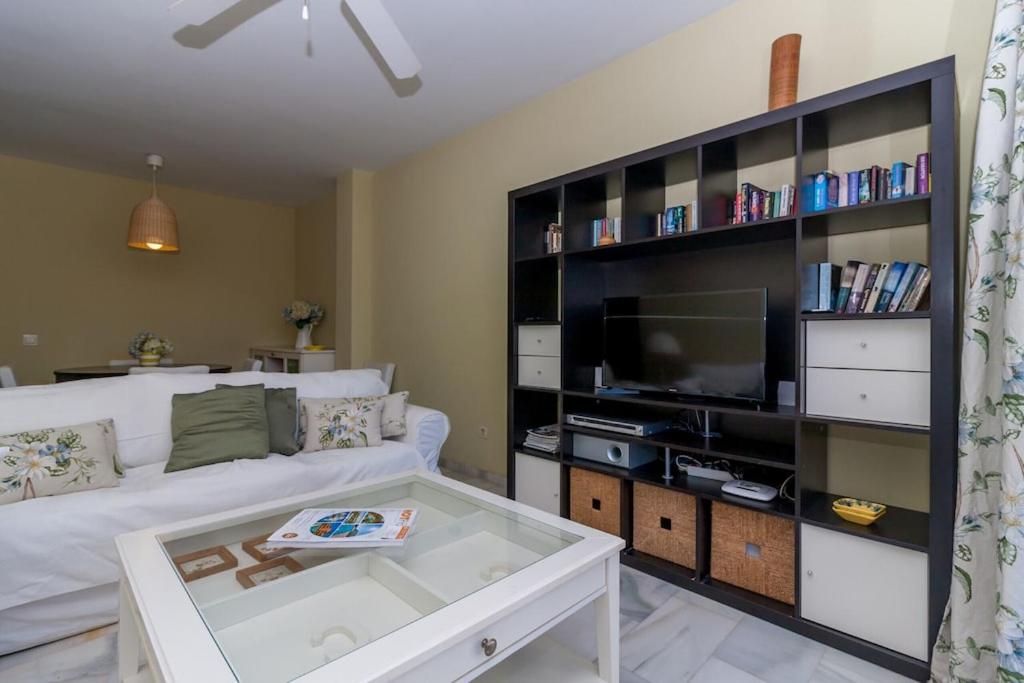 salon z białą kanapą i telewizorem w obiekcie Canovas Nerja - Alcazaba Parador, piscina, 2 dorm w mieście Nerja