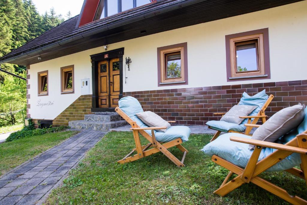 grupa krzeseł siedzących przed domem w obiekcie Estate Žagmeštri w mieście Ljubno