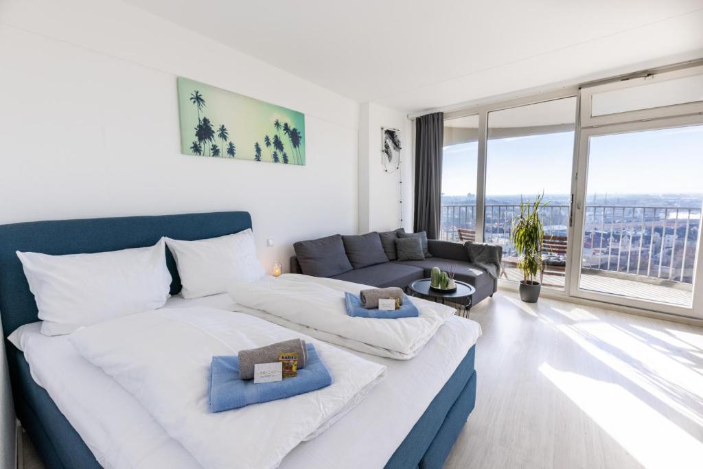 uma sala de estar com um sofá e uma grande janela em Arbio I Balcony Apartments Augsburg em Augsburg