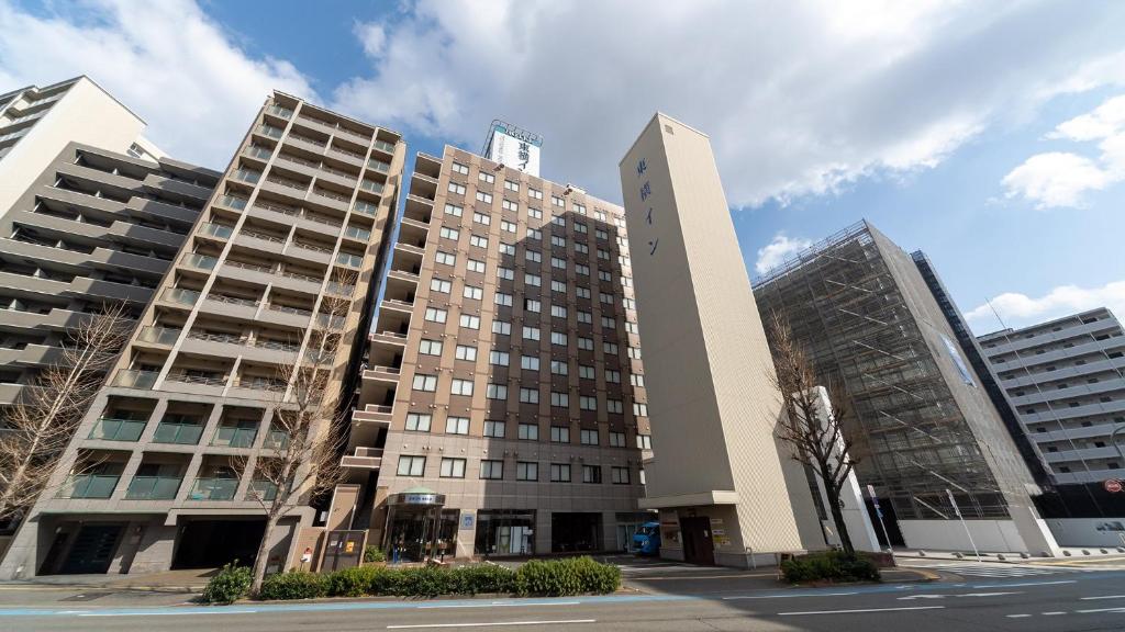 a large building with two tall buildings next to a street at Toyoko Inn Hakata-eki Minami in Fukuoka