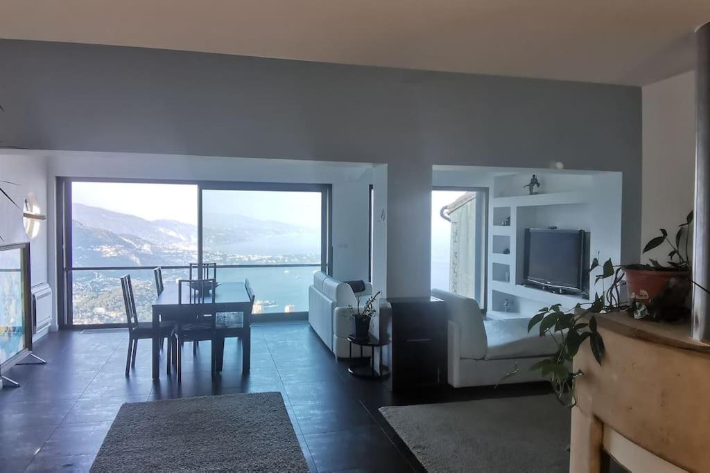 uma sala de estar com um sofá, uma mesa e uma televisão em Villa with unique & breathtaking view over Sea, Monte-Carlo, Italy & Alps em La Turbie