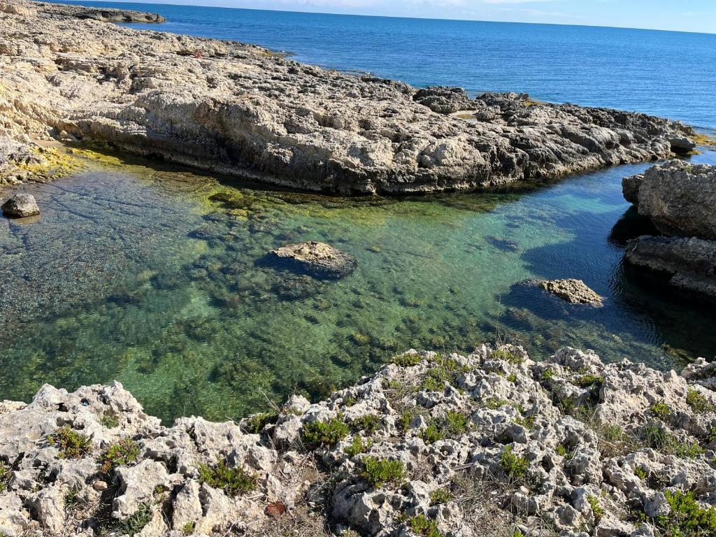 un cuerpo de agua con rocas y el océano en Casa LiaLara Mare, en Augusta
