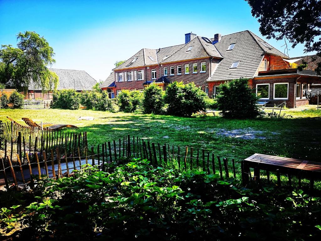 une maison avec une clôture devant une cour dans l'établissement Gästehaus Maria Rast, à Suderburg