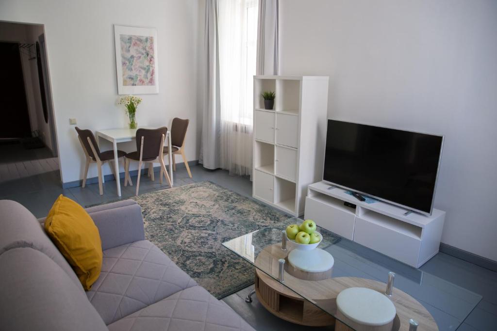 a living room with a couch and a flat screen tv at Arida Apartments in Rīga