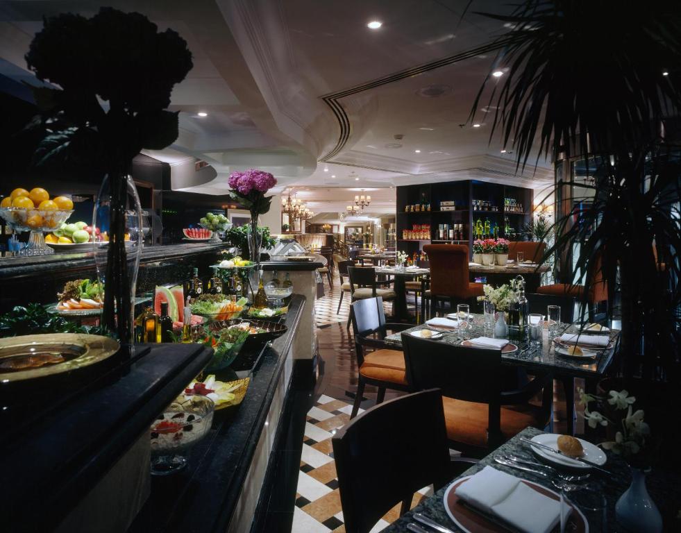 un restaurante con una línea de buffet con mesas y sillas en Sheraton Khalidiya Hotel, en Abu Dabi