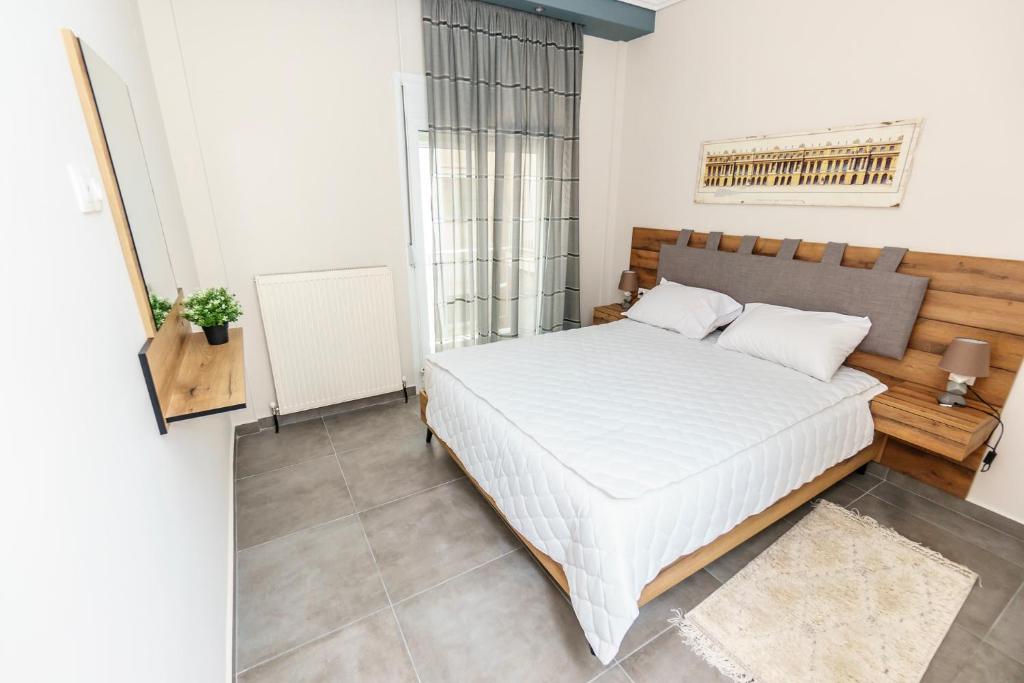 ein Schlafzimmer mit einem weißen Bett und einem großen Fenster in der Unterkunft Stylish Urban Getaway by thesbnb in Thessaloniki