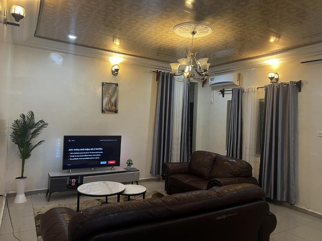 a living room with a couch and a flat screen tv at CASILINA GUEST HOME in Limbe