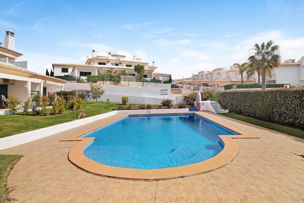 a swimming pool in front of a house at Villa Harvey in Albufeira
