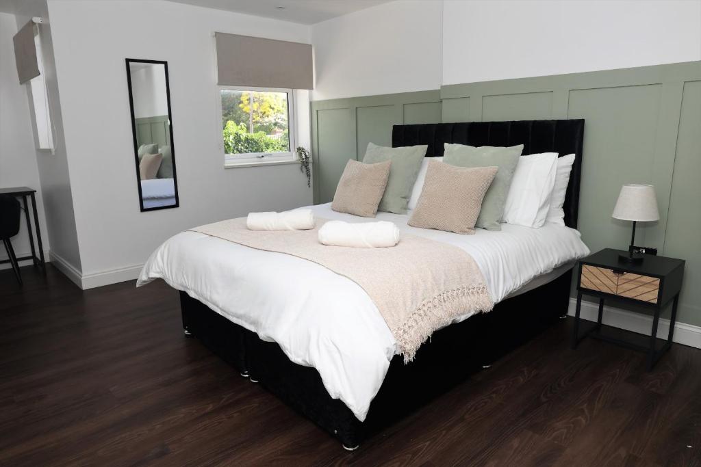 a bedroom with a large bed with two towels on it at Watford Luxury 1 Bed Flat - Free Parking in Watford