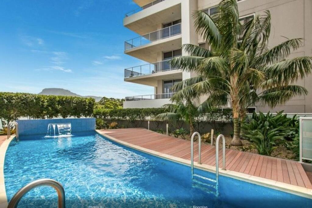 uma imagem de uma piscina em frente a um edifício em The Nines em Wollongong