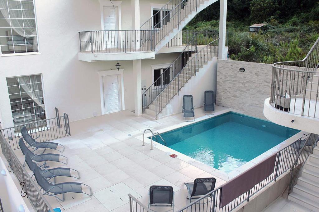 ein Gebäude mit einem Pool und einem Haus in der Unterkunft Apartment Felicita Prcanj Boko Kotor in Kotor