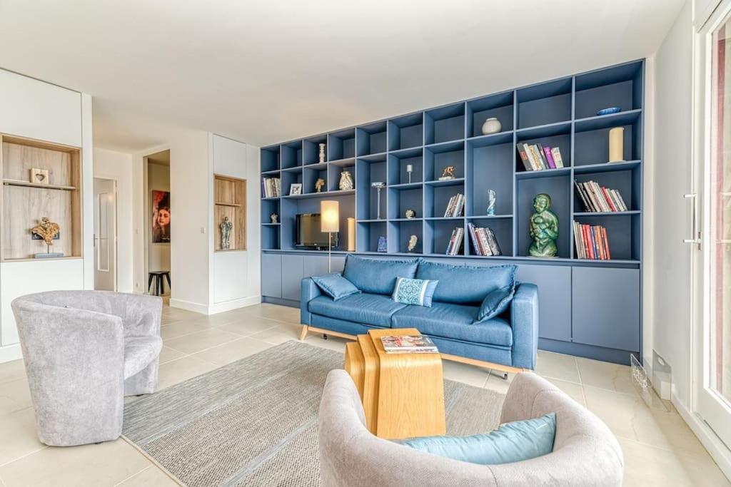 un salon avec un canapé bleu et des chaises dans l'établissement 117 liberation GRENOBLE, à Grenoble