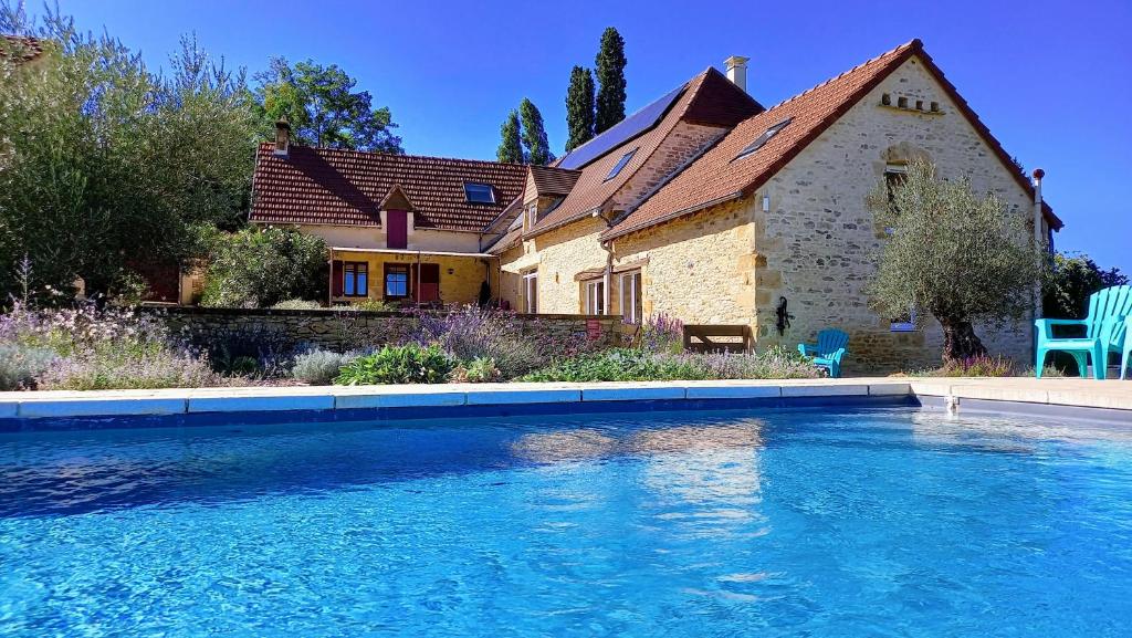 a house and a swimming pool in front of a house at Clos Lamonzie in Sarlat-la-Canéda