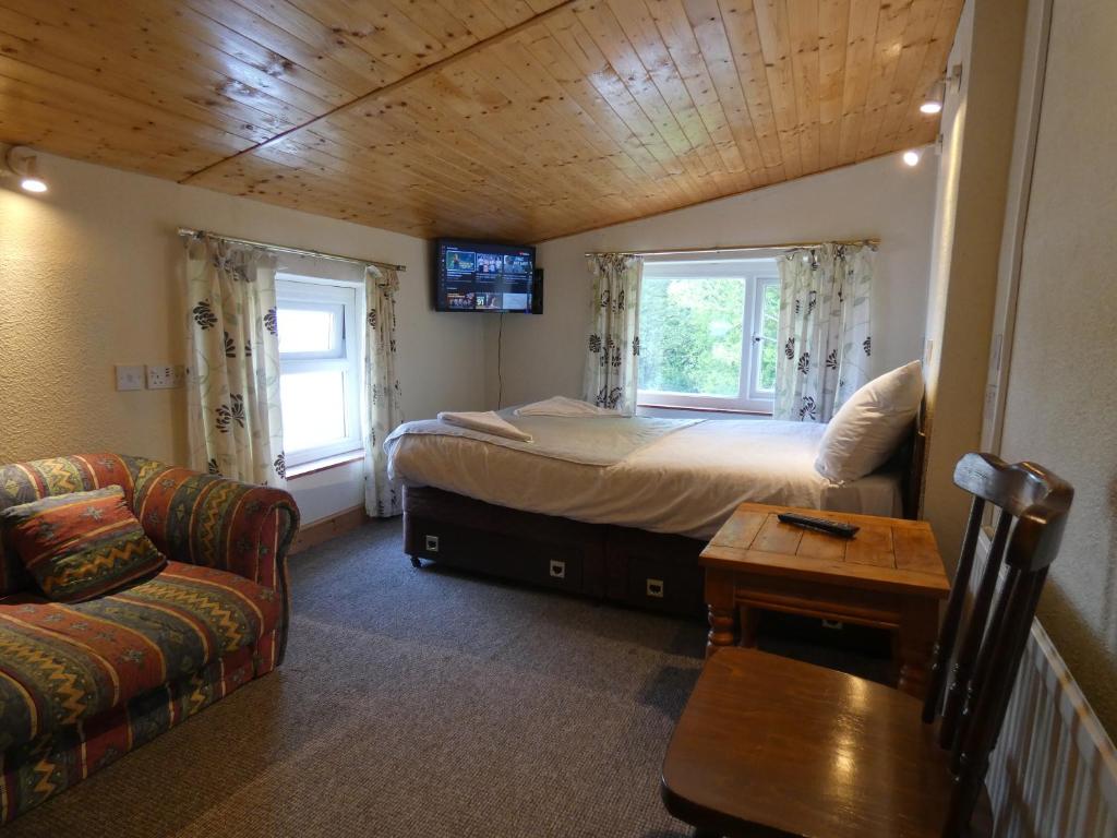 マーサー・ティドビルにあるHill Breeze Houseのベッドルーム1室(ベッド1台、ソファ、テーブル付)