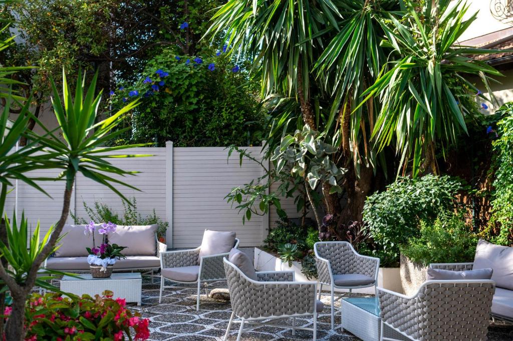 een patio met een bos stoelen en planten bij Hotel Helios in Diano Marina