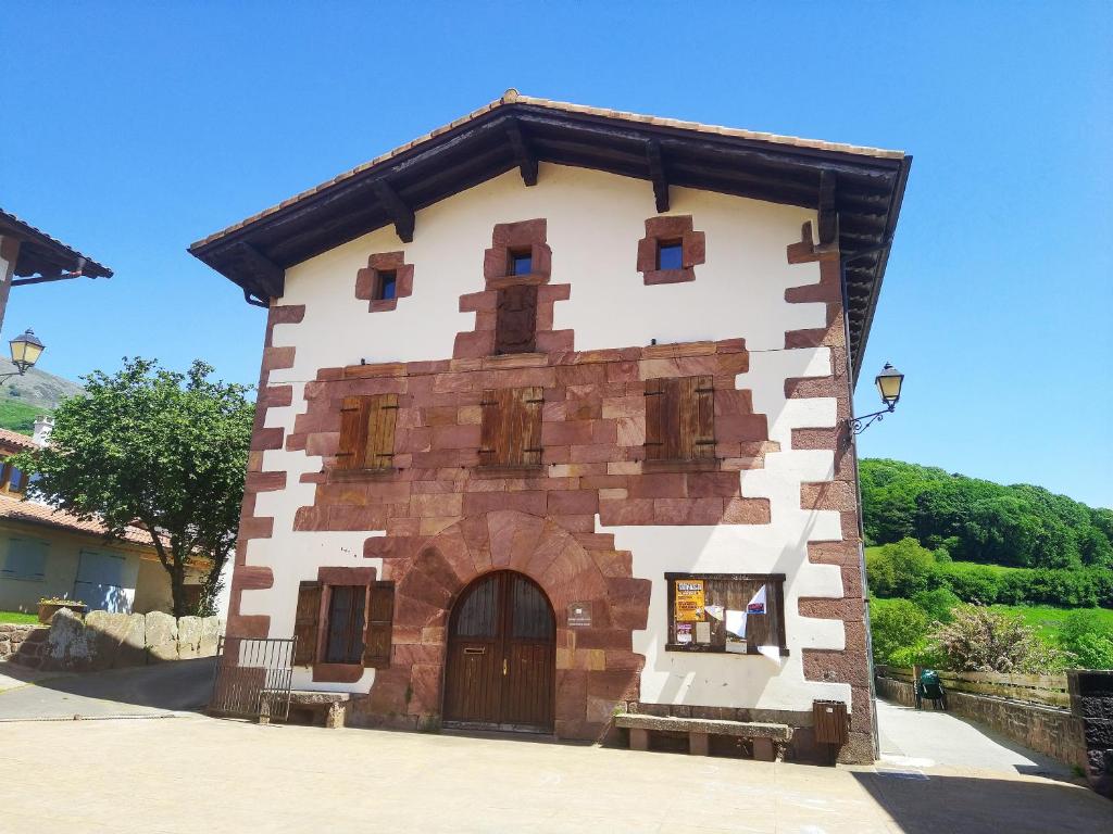 a small brick building with a large door at Amaiurko Aterpea in Maya del Baztán