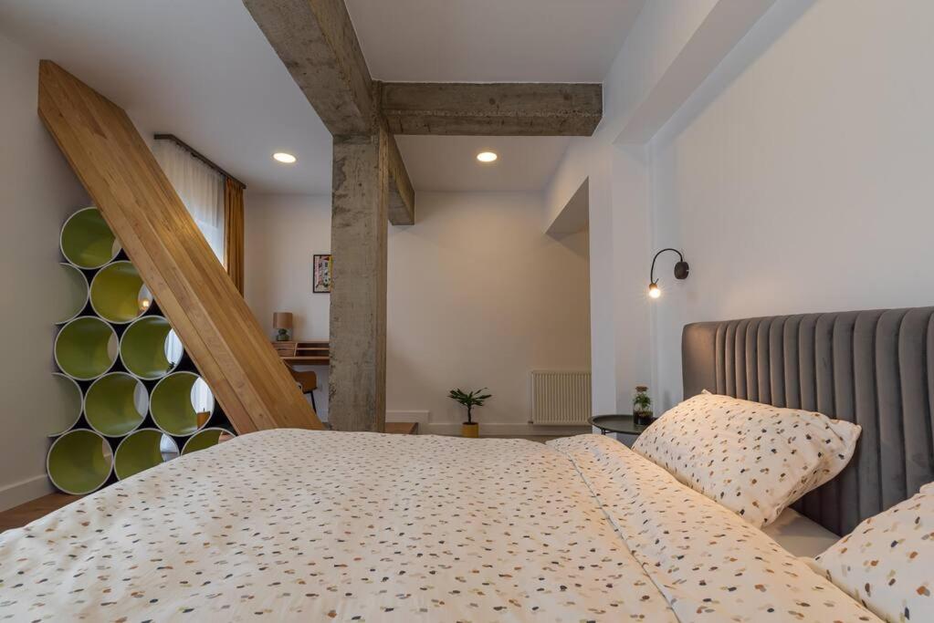 1 dormitorio con 1 cama con cabecero de madera en Fabrica Apartments 13, en Cluj-Napoca