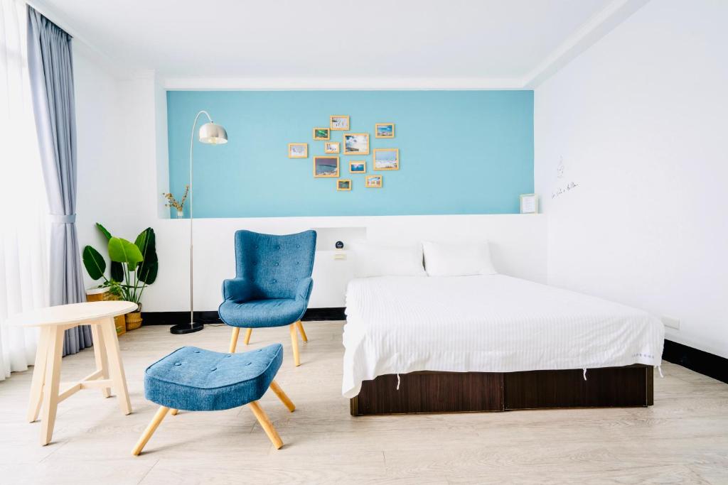 台東市的住宿－烏托邦國際青年旅舍，一间卧室配有一张床和一张蓝色椅子