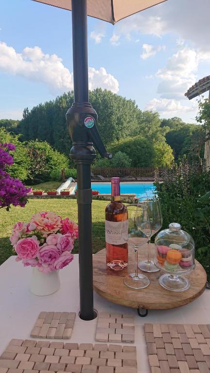 a table with a bottle of wine and two glasses at La Colline de Tilleul - De La Colline - Beautiful Cottage Near Aubeterre in Saint-Romain