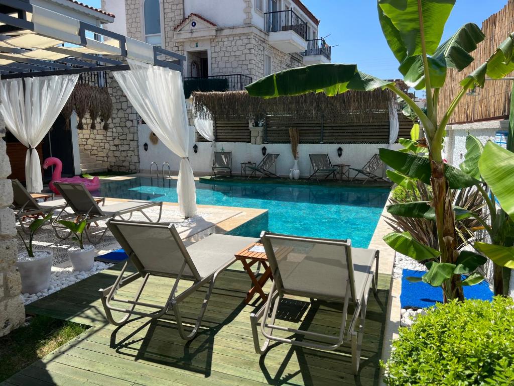 a patio with chairs and a swimming pool at My Angels Alaçatı in Alaçatı