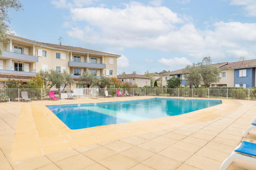 una piscina frente a un edificio en Appart'City Classic Bordeaux Aéroport St Jean D'Illac en Saint-Jean-dʼIllac