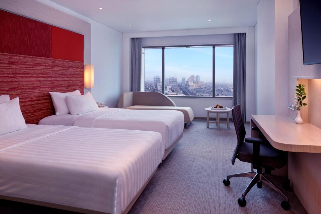 Postel nebo postele na pokoji v ubytování Grand Mercure Jakarta Harmoni