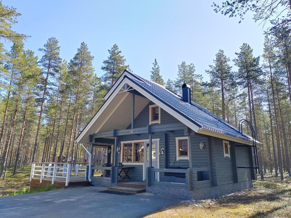 une petite maison bleue au milieu d'une forêt dans l'établissement Villa Särkkä, à Kalajoki