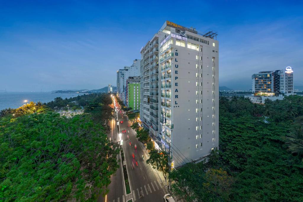 a tall white building on the side of a street at Blue Pearl Hotel in Nha Trang