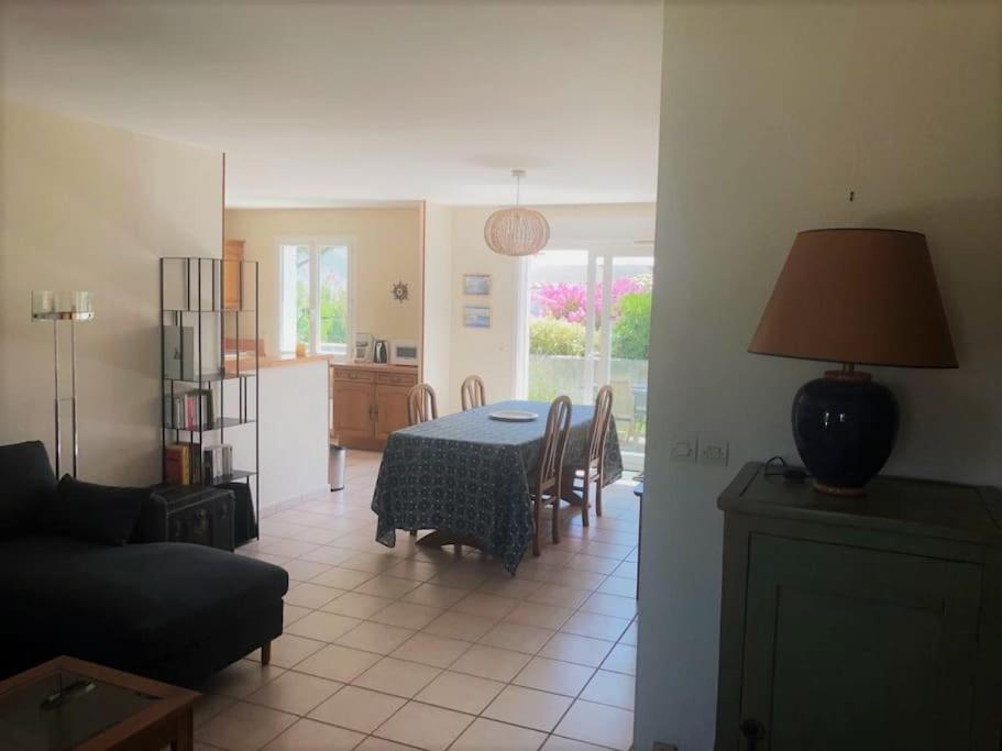 sala de estar con mesa y cocina en Agréable maison ensoleillée avec jardin arboré en Le Château-dʼOléron