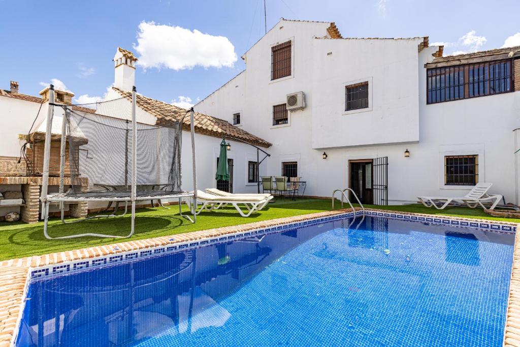 a villa with a swimming pool in front of a house at Casa Jimena 2 personas in Jimena de la Frontera