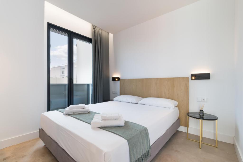 um quarto com uma grande cama branca e uma janela em Stayaday Apartments Albufera em Madri