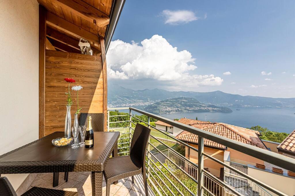 d'un balcon avec une table et une vue sur l'eau. dans l'établissement La Dolce Vita - Vista Lago e Piscina, à Parzanica