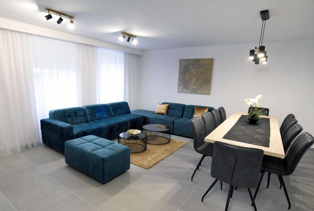 a living room with a blue couch and a table at Commodious house in Rijeka with 5 bedrooms in Rijeka