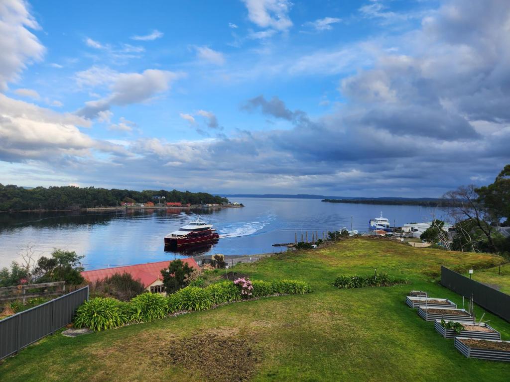 a view of a river with a boat in the water at Bayviews in Strahan