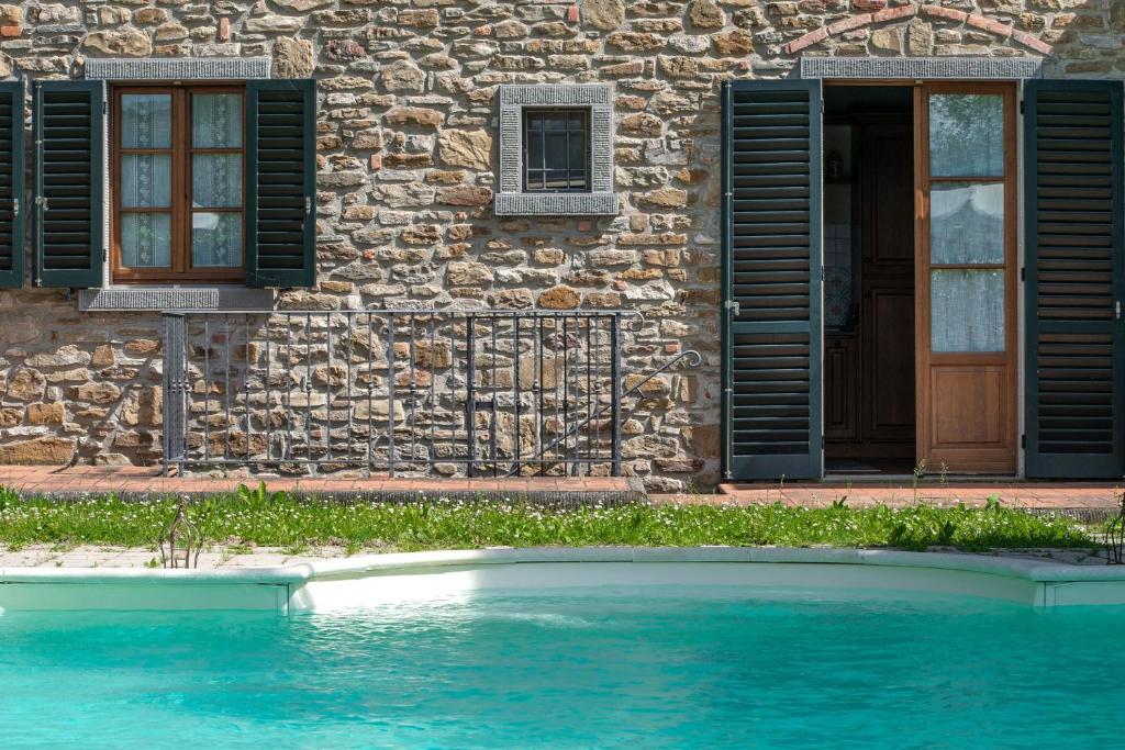 SubbianoにあるExperience the charm of Tenuta Le Caselle, a cozy farmhouse surrounded by nature and comfort!の建物前のスイミングプール付き住宅