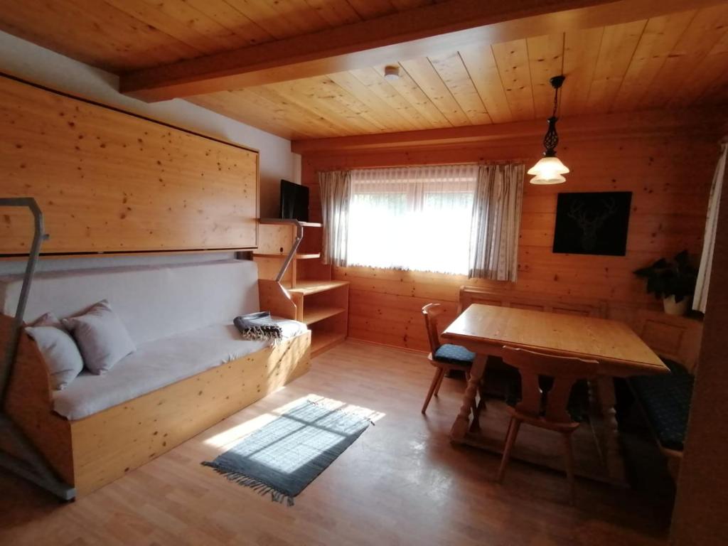 um quarto com uma cama e uma mesa num quarto em Haus Obweg - Postalm em Hallein