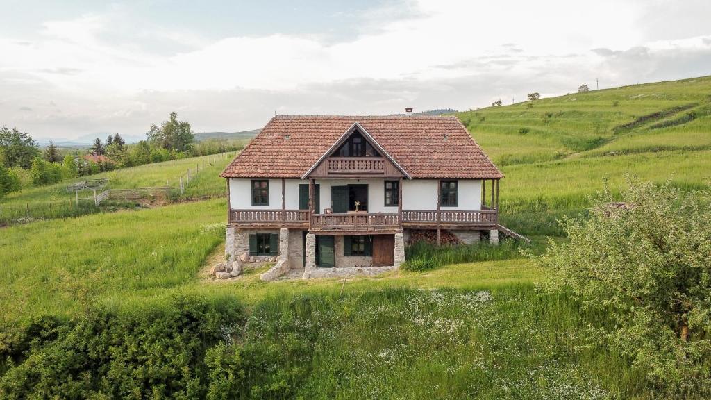 una vieja casa en una colina en un campo en Hillside View Cottage - Csíksomlyó-panoráma vendégház, en Păuleni-Ciuc