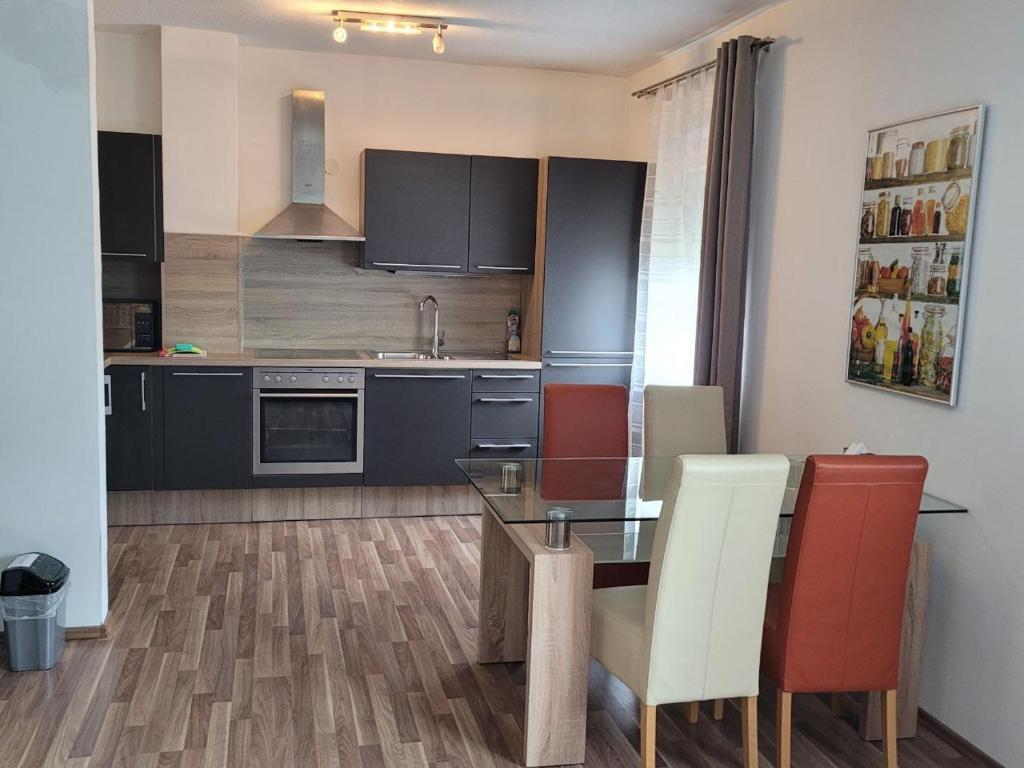 kuchnia ze szklanym stołem i czerwonymi krzesłami w obiekcie Zentral gelegene, sehr ruhige und helle Wohnung w Grazu