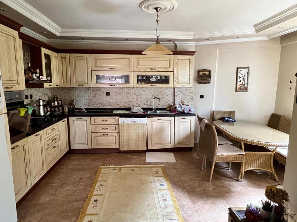 una cocina con armarios blancos y una mesa. en Trabzon Villa en Kireçhane