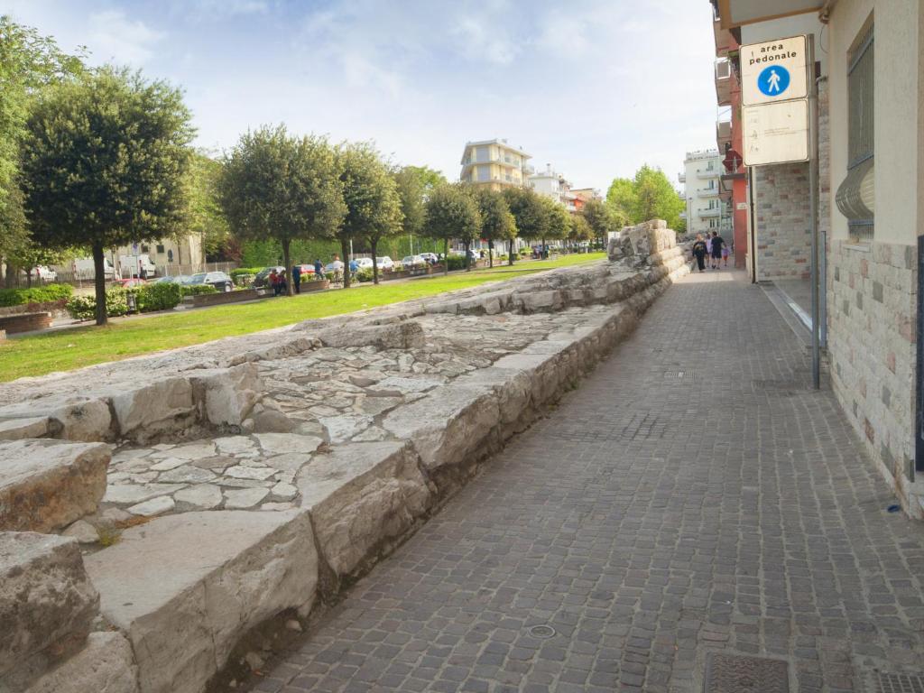 a stone retaining wall next to a street at Hotel del Mar in Sottomarina