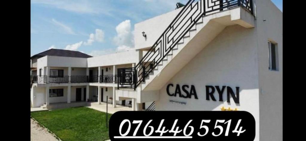 a white building with a sign in front of it at Casa Ryn in Vama Veche